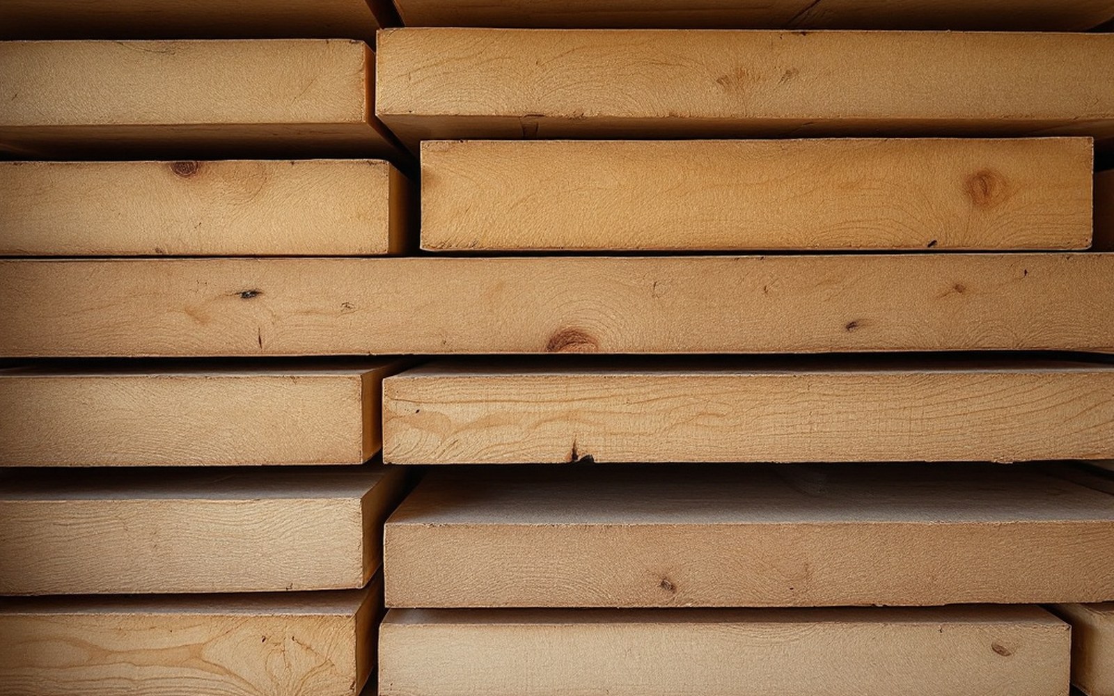 Rough spruce shelving boards stacked in a cellar with cheese rind marks on their surfaces